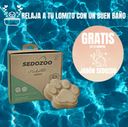Caja de jabón Sedozoo y jabón con forma de huella sobre un fondo de agua azul.