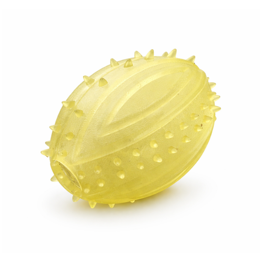 Pelota ovalada amarilla para perro, con púas y surcos en la superficie.