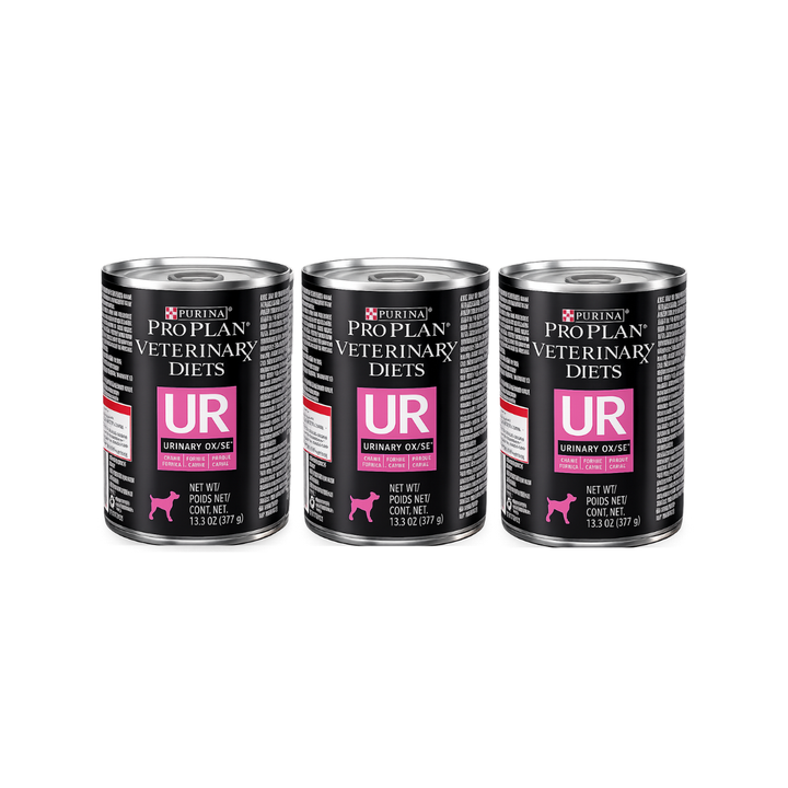 Tres latas de Purina Pro Plan Veterinary Diets UR Urinary Ox/St para perros, con etiquetas negras y rosas.